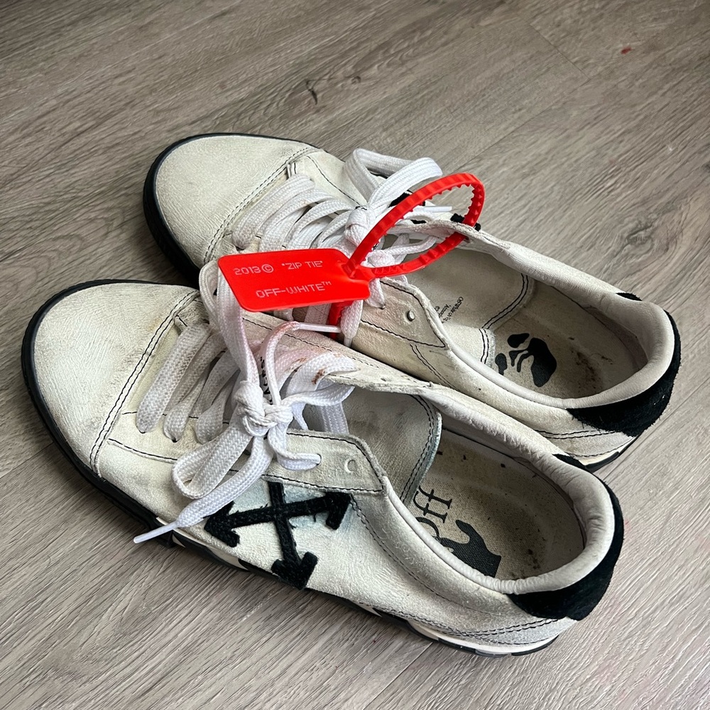 Very used/worn off-white brand sneakers.